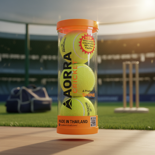 "Adoral Professional Cricket Tennis Balls tube packaging with three bright yellow balls inside, orange lid and branding, displayed on cricket pitch bench with stadium stumps and equipment in background, sunlight flare highlighting the tube"

